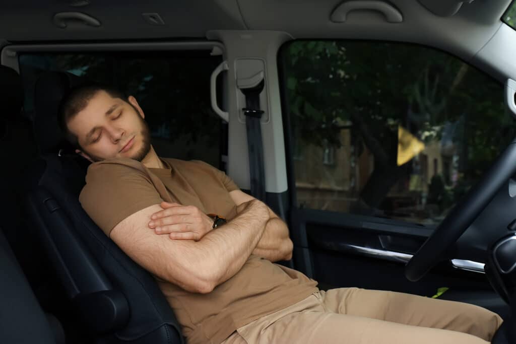 Man sleeping in his car